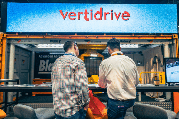 B5200_Jimi Vanderpool Talking to Attendee as Vertidrive is on LED Screen on Booth (1) B5200_Jimi Vanderpool Talking to Attendee as Vertidrive is on LED Screen on Booth (1)